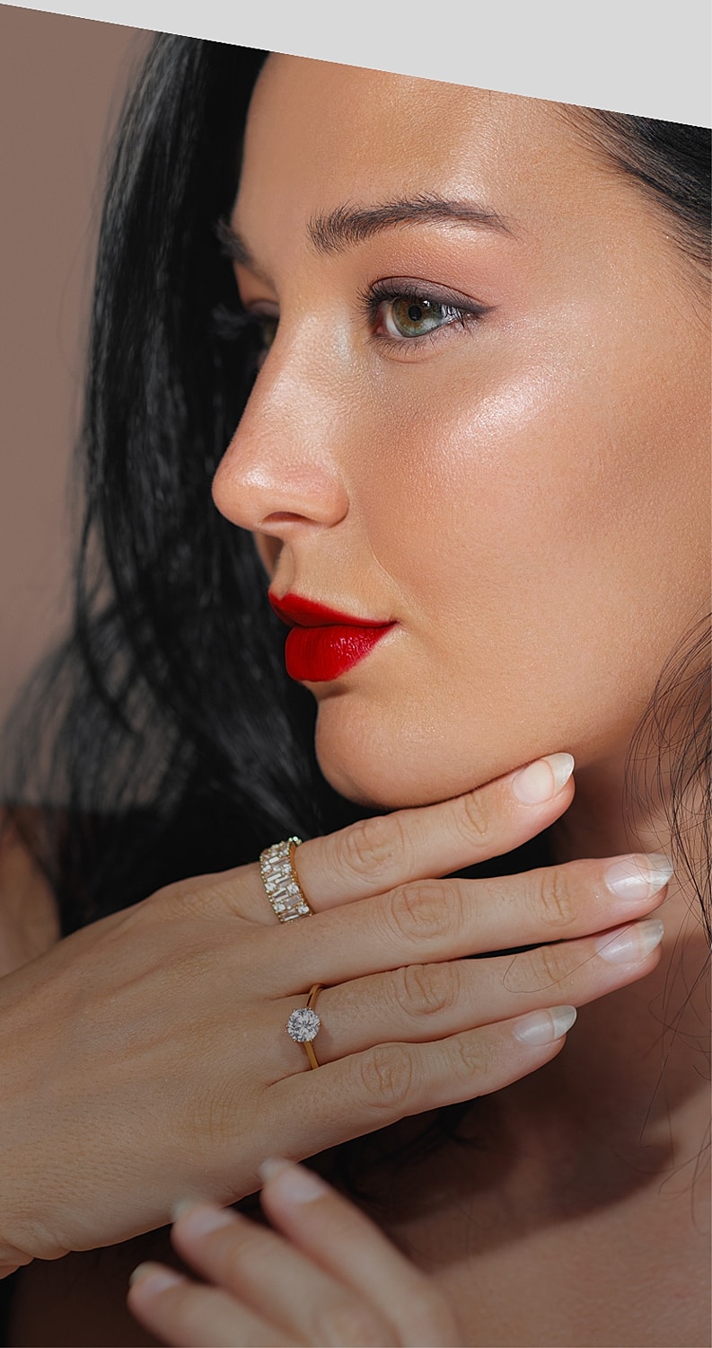 Woman with elegant rings and bold red lipstick.