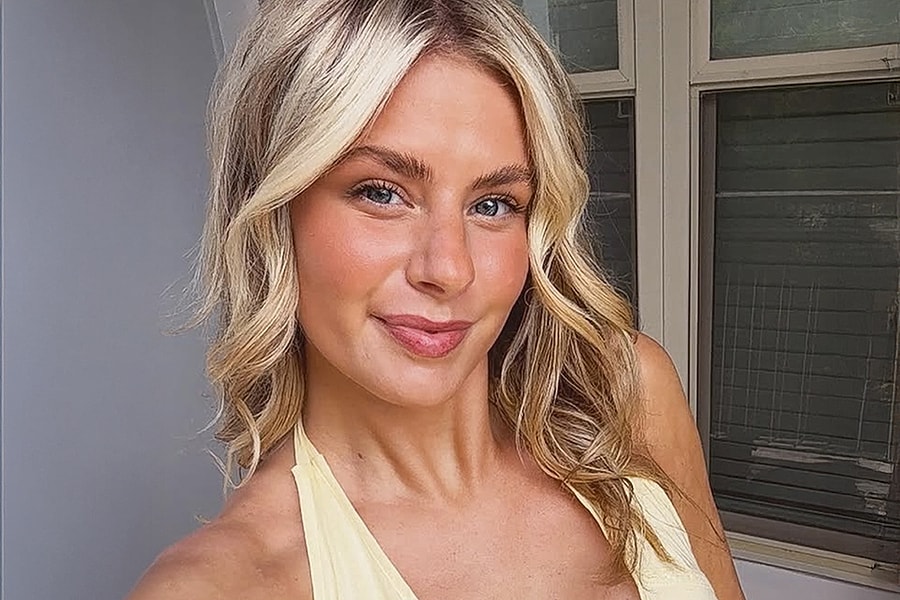 Smiling person in yellow top taking selfie.